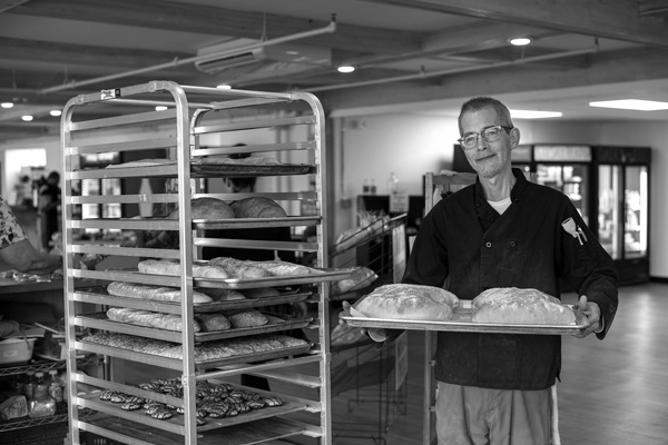 Head baker Shayne Williams holds a tray of freshly baked loaves of bread at the new Bennington Community Market. Joan K. Lentini photo Head baker Shayne Williams holds a tray of freshly baked loaves of bread at the new Bennington Community Market. Joan K. Lentini photo