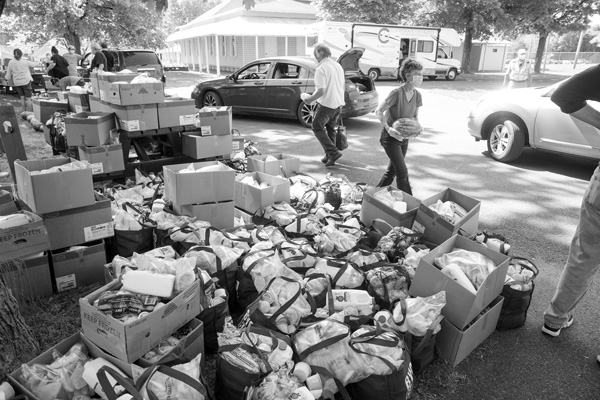 Volunteers at a food distribution event load boxes and bags into cars that formed a long line last month at the Columbia County Fairgrounds. Photo by Scott Langley
Volunteers at a food distribution event load boxes and bags into cars that formed a long line last month at the Columbia County Fairgrounds. Photo by Scott Langley